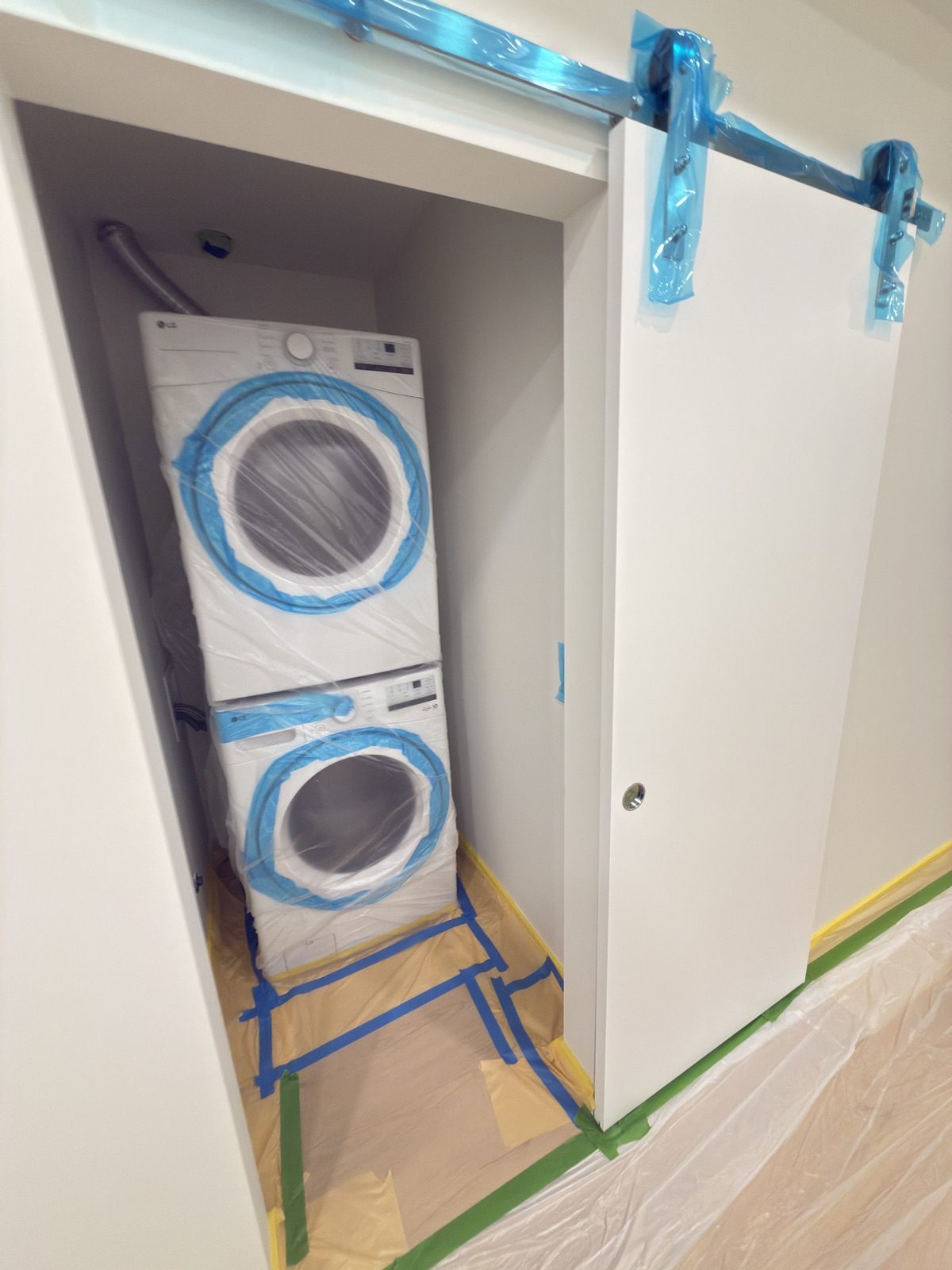 Stacked washer and dryer wrapped in plastic film before air sealing